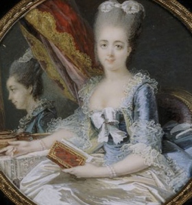 A duchesse sitting in front of a mirror holding a book.